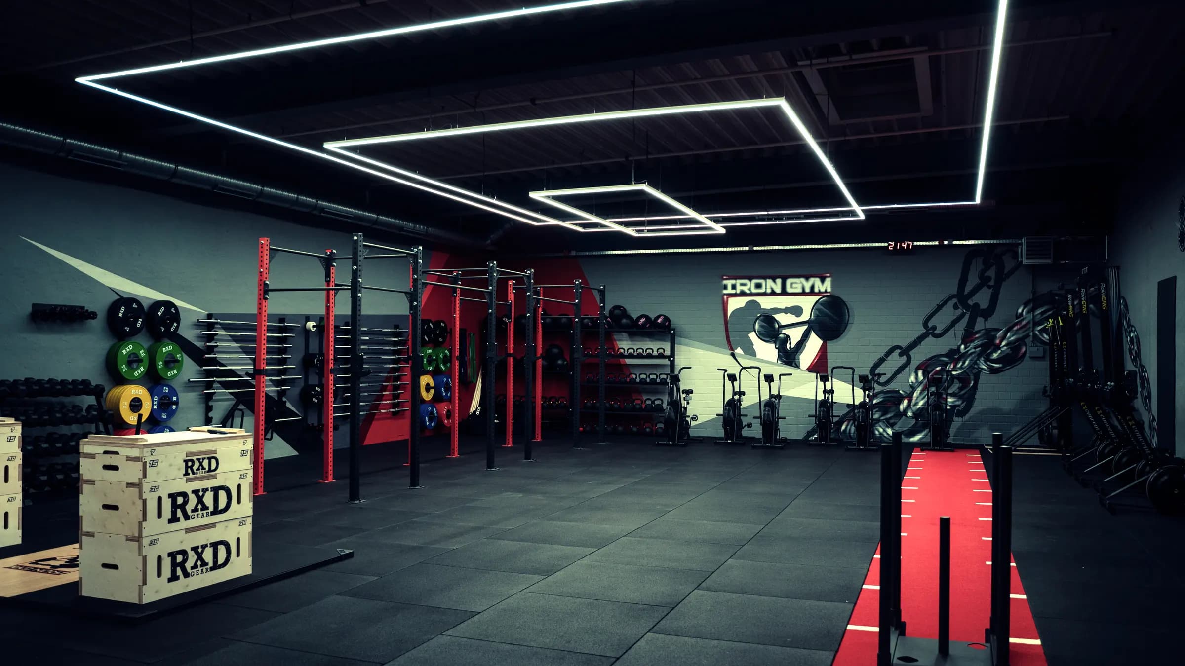 HYROX-Fläche im Iron Gym Viersen mit Rigs, Sled-Bahn und Hantelscheiben vor der Iron Gym Logowand